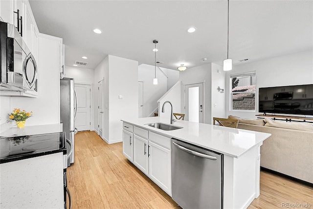 4027 E 98th Pl, Thornton, CO 80229 - kitchen with appliances with stainless steel finishes, a sink, light wood finished floors, white cabinets, and recessed lighting