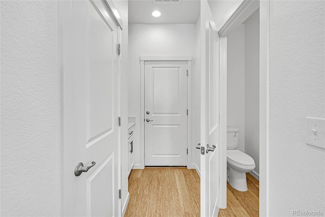 4027 E 98th Pl, Thornton, CO 80229 - corridor featuring light wood-style floors, a textured wall, and recessed lighting