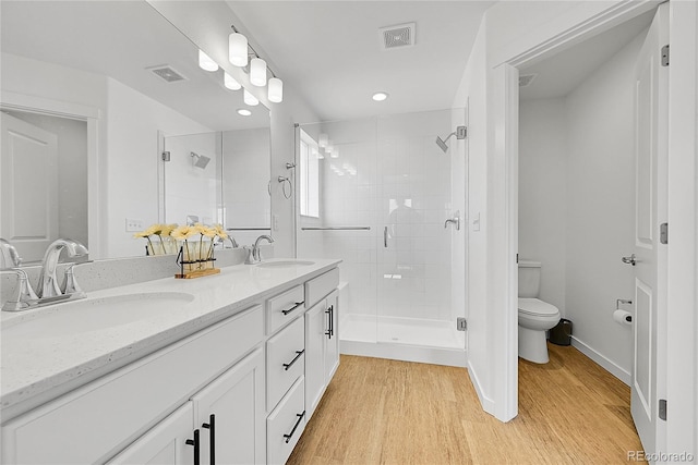 4027 E 98th Pl, Thornton, CO 80229 - bathroom with a stall shower, double vanity, toilet, wood finished floors, and recessed lighting