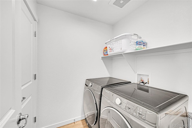 4027 E 98th Pl, Thornton, CO 80229 - laundry area with washer and clothes dryer, baseboards, and light wood finished floors