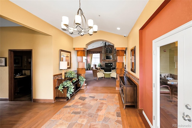 4027 E 98th Pl, Thornton, CO 80229 - hallway with lofted ceiling, light wood-style flooring, arched walkways, and a chandelier