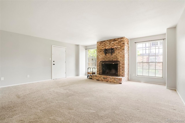 unfurnished living room featuring carpet, a fireplace, and baseboards
