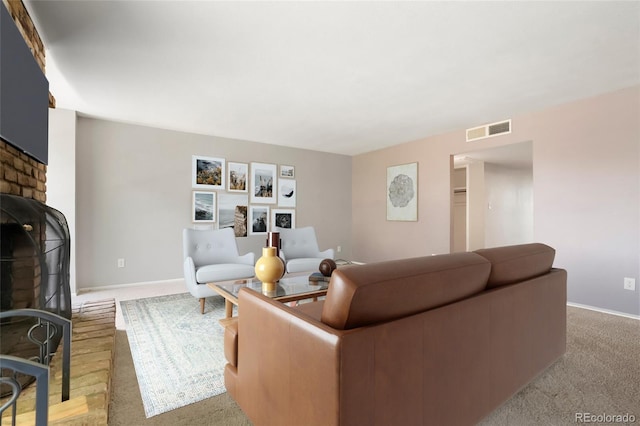 living area featuring baseboards, a fireplace, and visible vents
