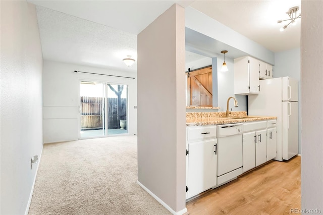 kitchen with a sink, pendant lighting, white cabinets, white appliances, and light countertops