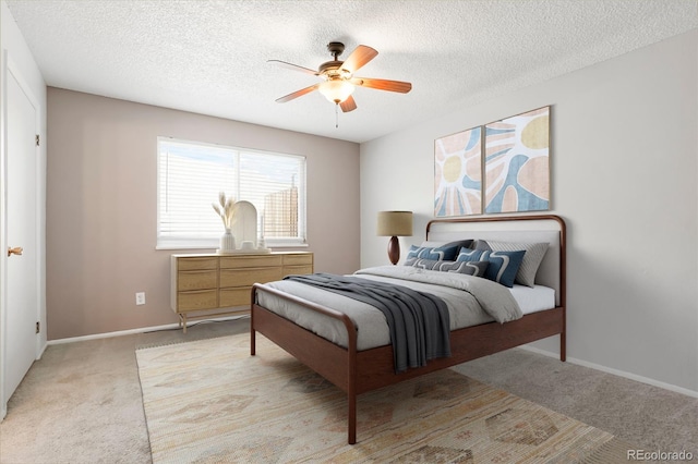 bedroom featuring light carpet, a textured ceiling, baseboards, and a ceiling fan