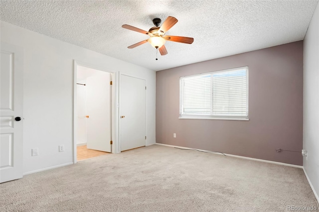 unfurnished bedroom with connected bathroom, a textured ceiling, baseboards, and carpet floors