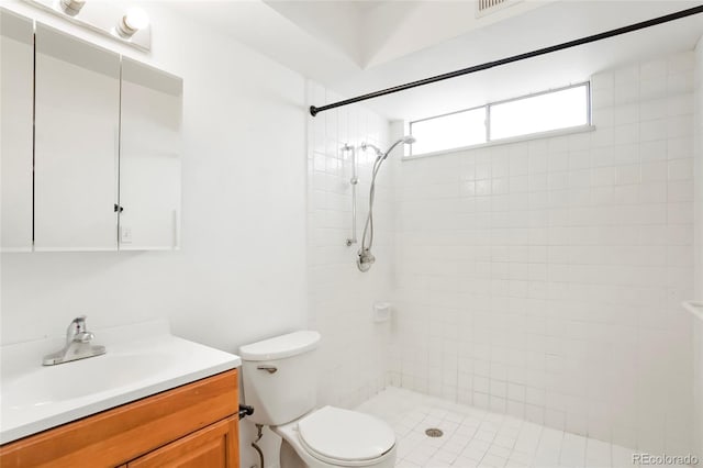 full bath with vanity, toilet, and a tile shower