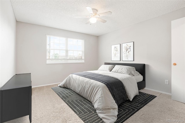 bedroom featuring ceiling fan, light carpet, a textured ceiling, and baseboards