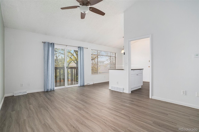 3405 W 16th St Unit 14C, Greeley, CO 80634 - unfurnished living room with ceiling fan, a textured ceiling, wood finished floors, vaulted ceiling, and baseboards