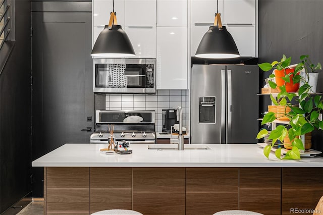 kitchen with decorative backsplash, sink, white cabinets, and appliances with stainless steel finishes