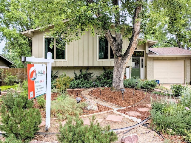 1080 Ithaca Dr, Boulder, CO 80305 - view of front facade featuring board and batten siding, an attached garage, brick siding, and roof with shingles