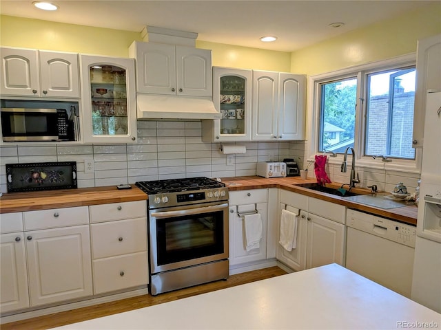 1080 Ithaca Dr, Boulder, CO 80305 - kitchen featuring stainless steel appliances, wood counters, under cabinet range hood, white cabinetry, and tasteful backsplash