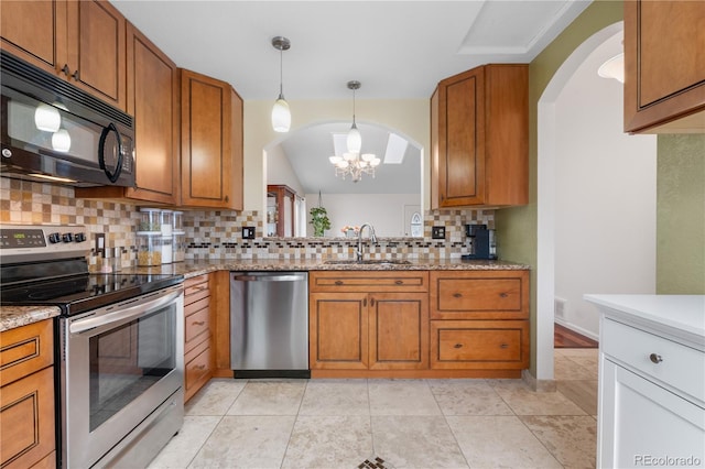 9960 Garland Ln, Broomfield, CO 80021 - kitchen featuring appliances with stainless steel finishes, a sink, arched walkways, backsplash, and brown cabinetry
