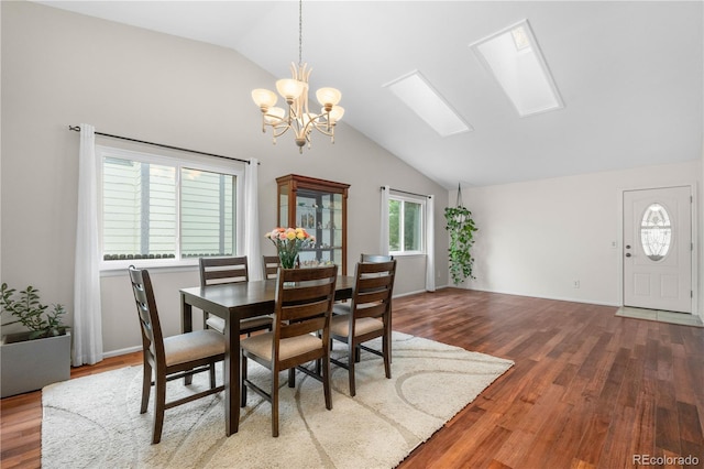 9960 Garland Ln, Broomfield, CO 80021 - dining room featuring lofted ceiling, a chandelier, wood finished floors, and a skylight