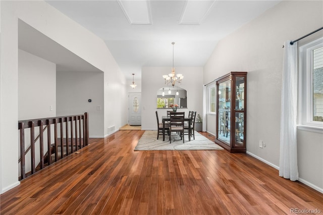 9960 Garland Ln, Broomfield, CO 80021 - dining room featuring wood finished floors, lofted ceiling, a chandelier, and baseboards