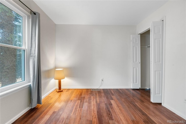 9960 Garland Ln, Broomfield, CO 80021 - unfurnished bedroom featuring wood finished floors, multiple windows, and baseboards