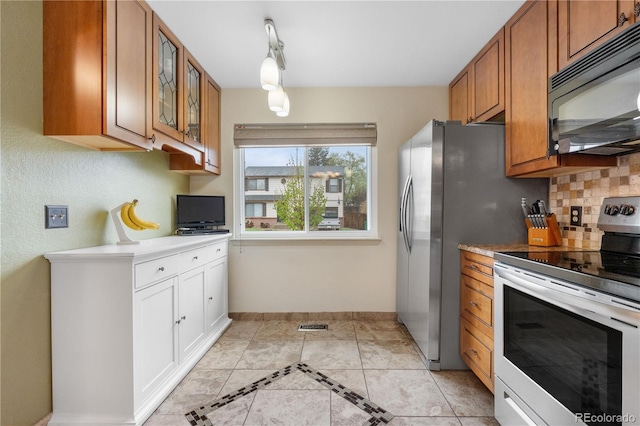 9960 Garland Ln, Broomfield, CO 80021 - kitchen with black microwave, range with electric cooktop, brown cabinets, glass insert cabinets, and decorative backsplash