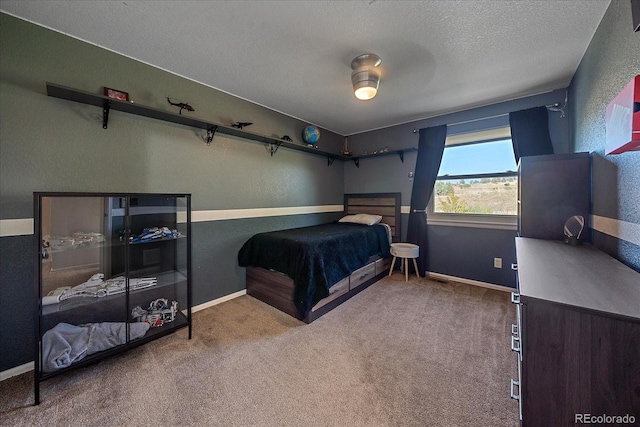 carpeted bedroom with ceiling fan and a textured ceiling