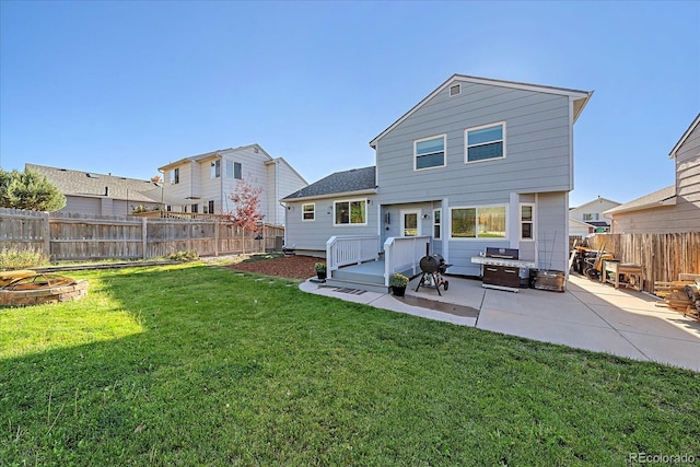 rear view of property with a lawn, a fire pit, and a patio area