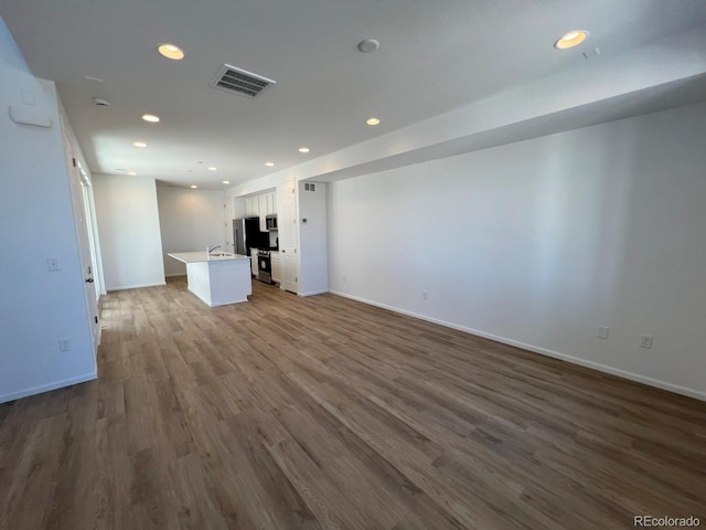 6601 N Netherland St, Aurora, CO 80019 - unfurnished living room with dark wood-type flooring and recessed lighting
