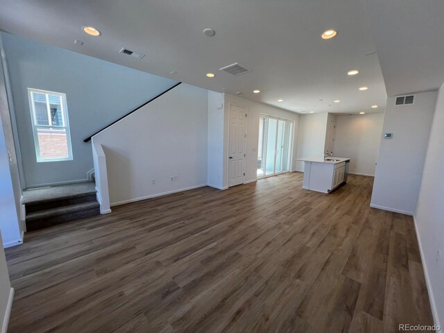 6601 N Netherland St, Aurora, CO 80019 - unfurnished living room featuring wood finished floors, stairway, and recessed lighting
