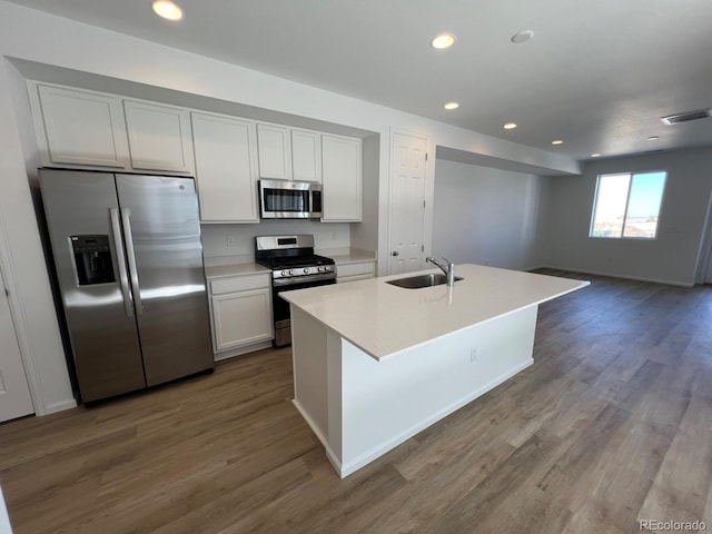 6601 N Netherland St, Aurora, CO 80019 - kitchen with appliances with stainless steel finishes, recessed lighting, dark wood-type flooring, white cabinets, and light countertops