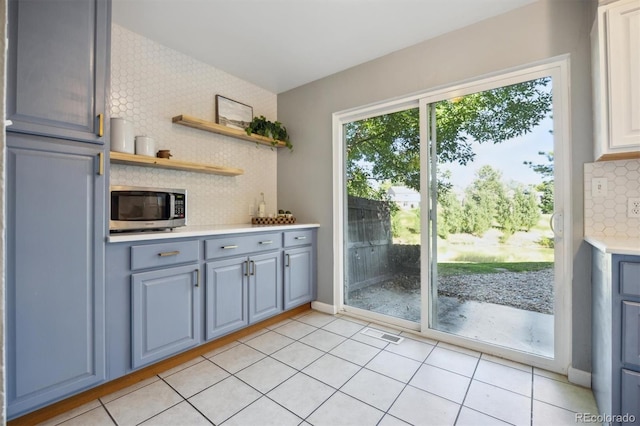 kitchen featuring decorative backsplash, light tile patterned floors, and gray cabinets