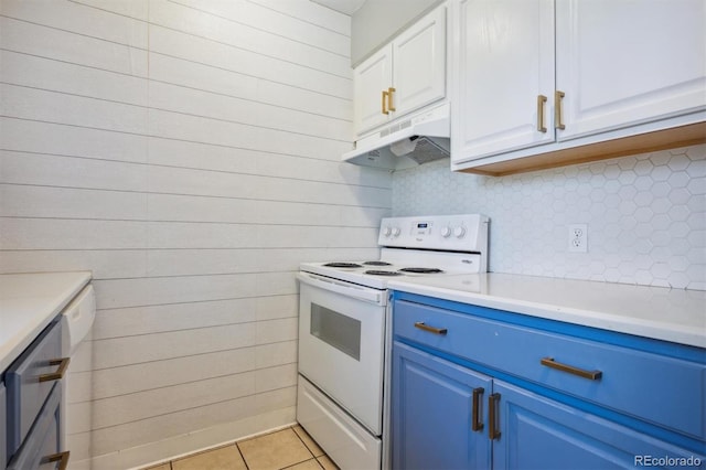 kitchen featuring white cabinetry, wood walls, light tile patterned floors, blue cabinets, and white electric range