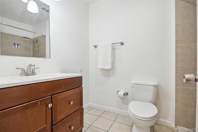 bathroom with a tile shower, tile patterned flooring, vanity, and toilet