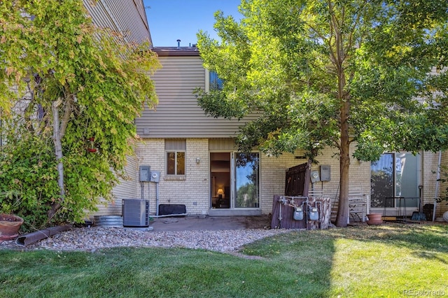 back of house with a lawn, central air condition unit, and a patio area