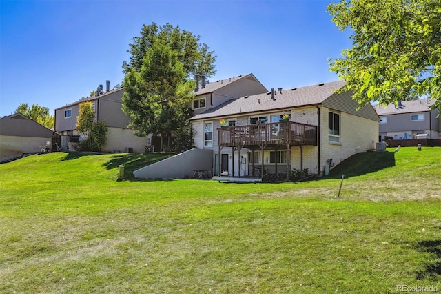 rear view of property with a wooden deck and a lawn