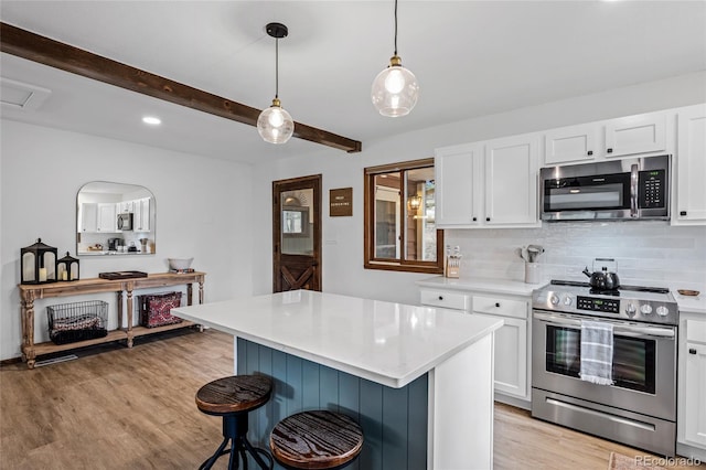 kitchen featuring stainless steel appliances, a kitchen breakfast bar, white cabinetry, and light hardwood / wood-style floors