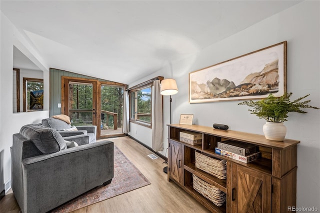 living room featuring light wood-type flooring and vaulted ceiling