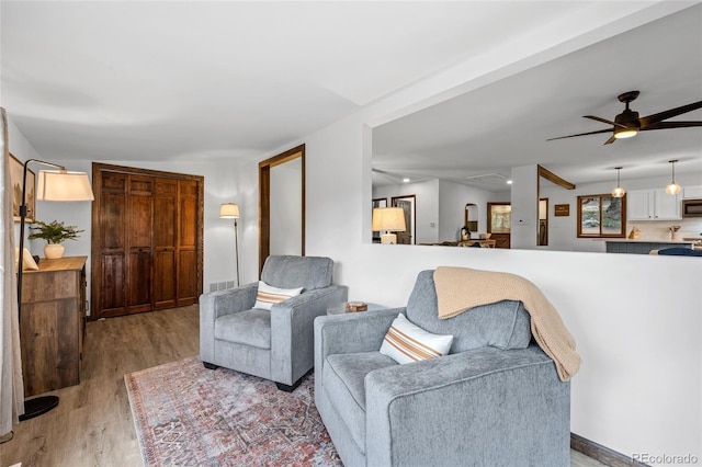 living room featuring light hardwood / wood-style flooring and ceiling fan