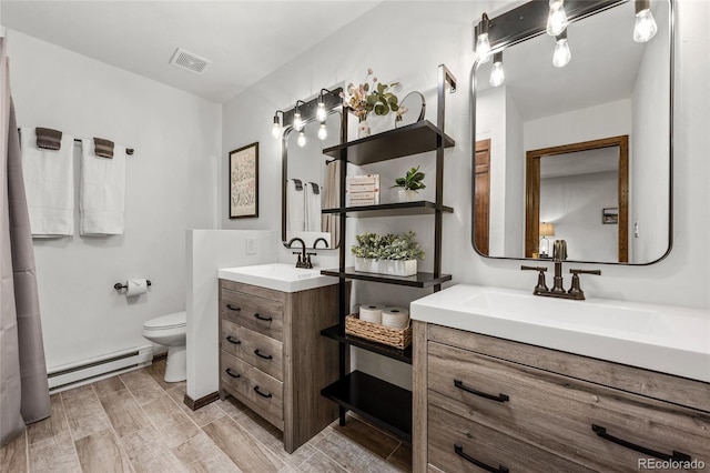 bathroom featuring hardwood / wood-style flooring, toilet, baseboard heating, and vanity