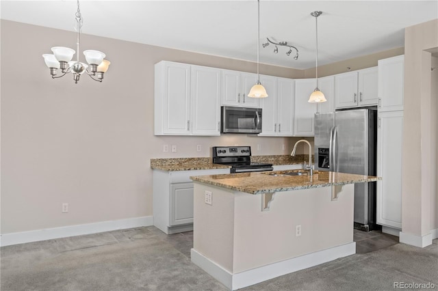 kitchen featuring stainless steel appliances, sink, a center island with sink, white cabinetry, and hanging light fixtures