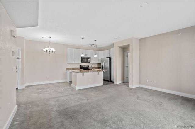 kitchen with pendant lighting, light carpet, white cabinets, appliances with stainless steel finishes, and a kitchen island