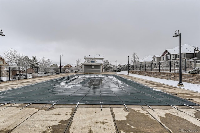 community pool featuring a patio area, a residential view, and fence