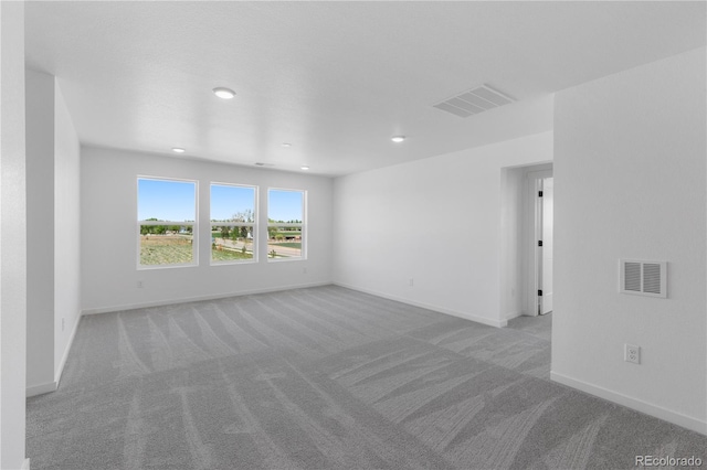 spare room featuring carpet flooring, baseboards, and recessed lighting