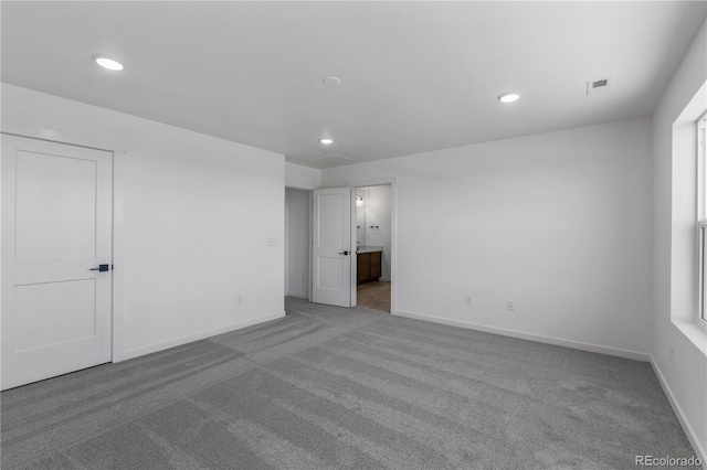 empty room featuring carpet floors, recessed lighting, and baseboards