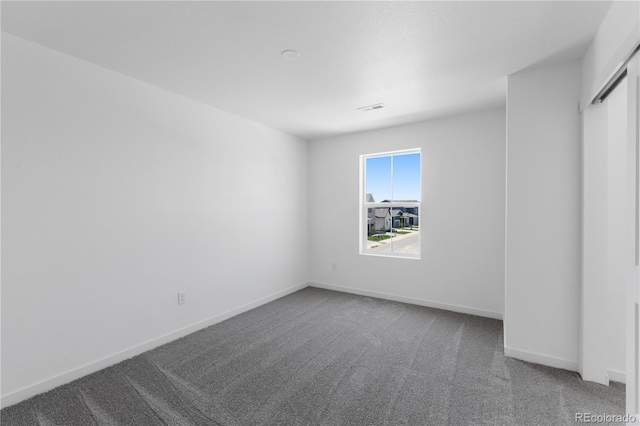 unfurnished room with carpet flooring and baseboards