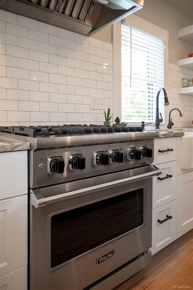 401 S Williams St, Denver, CO 80209 - kitchen with luxury range, tasteful backsplash, extractor fan, white cabinetry, and open shelves