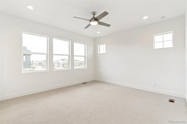 carpeted spare room with ceiling fan