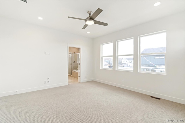 unfurnished bedroom with ceiling fan, connected bathroom, and light carpet