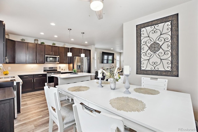 2395 S Troy Ct, Aurora, CO 80014 - kitchen featuring appliances with stainless steel finishes, a center island, dark brown cabinetry, recessed lighting, and light countertops