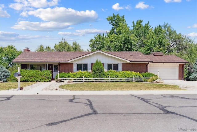 9 Rangeview Dr, Wheat Ridge, CO 80215 - ranch-style home with brick siding, an attached garage, a chimney, and driveway