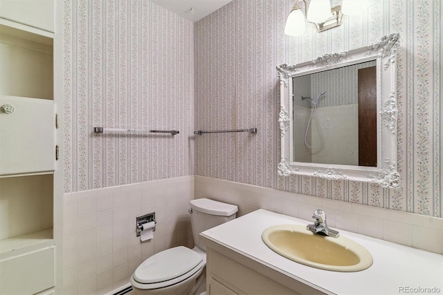 9 Rangeview Dr, Wheat Ridge, CO 80215 - bathroom with vanity, wallpapered walls, wainscoting, a shower, and tile walls