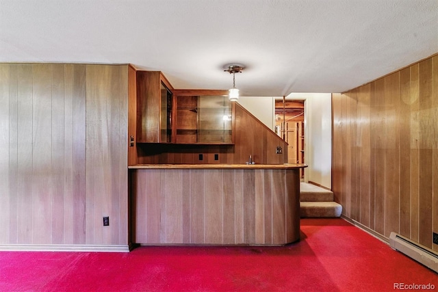 9 Rangeview Dr, Wheat Ridge, CO 80215 - kitchen featuring baseboard heating, wooden walls, carpet, brown cabinets, and glass insert cabinets
