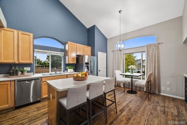5796 E 129th Pl, Thornton, CO 80602 - kitchen with appliances with stainless steel finishes, high vaulted ceiling, light countertops, a breakfast bar area, and dark wood-style floors