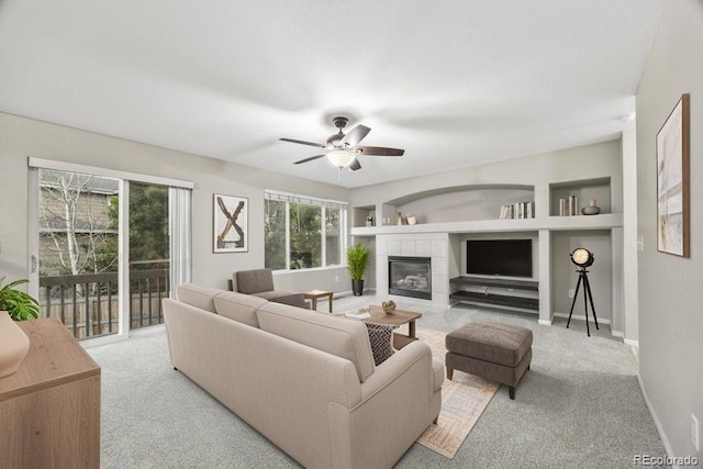 5796 E 129th Pl, Thornton, CO 80602 - living room with carpet floors, a tiled fireplace, ceiling fan, and built in shelves